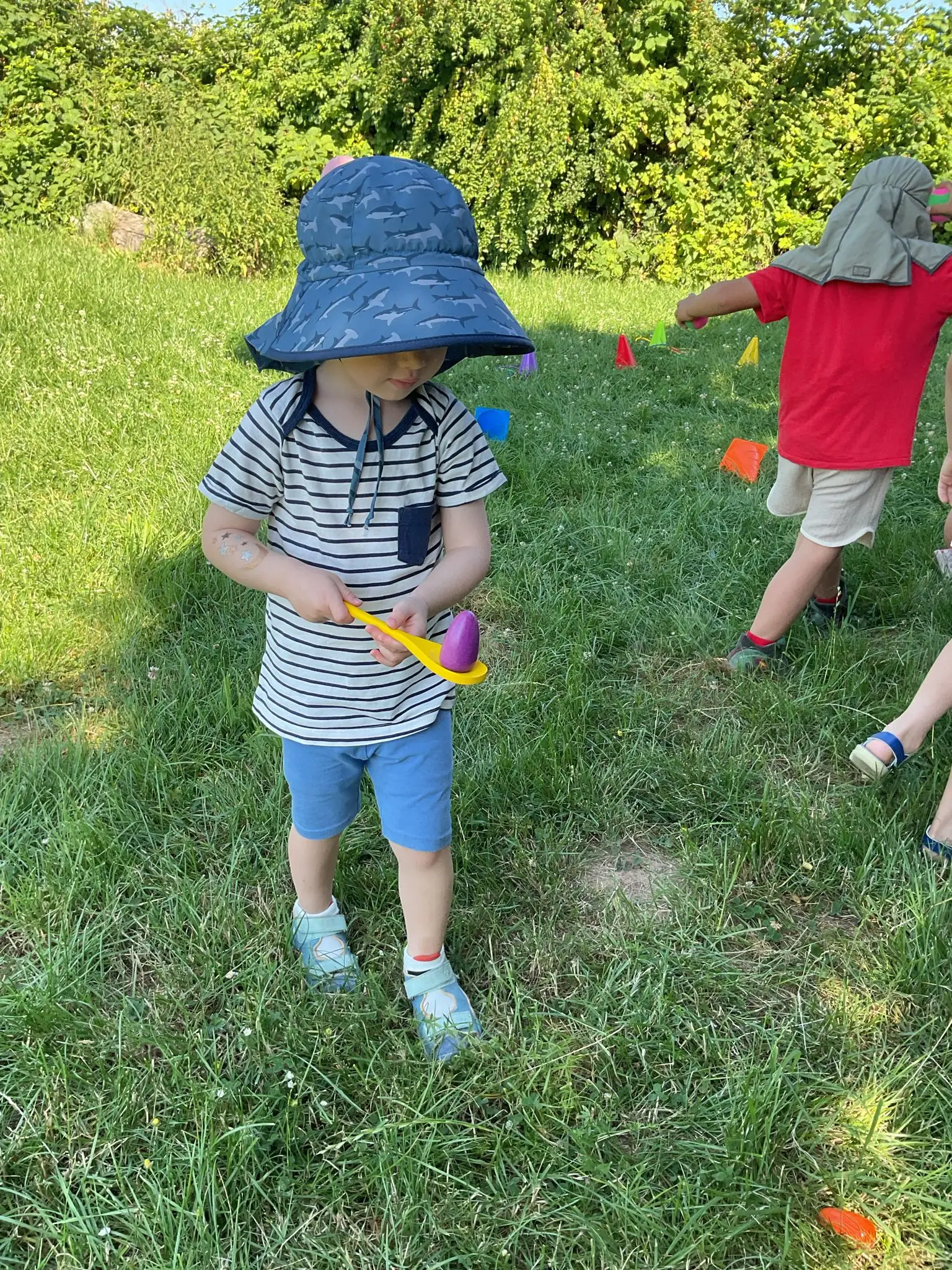 Child playing an egg-and-spoon relay race game outdoors
