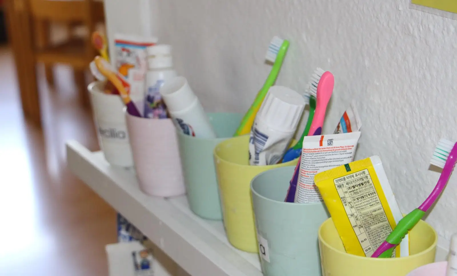 Labeled toothbrush cups on a shelf in the TIMS classroom self-care station